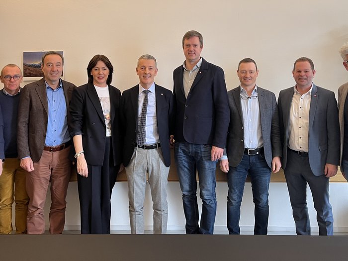 Il futuro dell‘artigianato: colloqui strategici tra lvh.apa e l’assessore Peter Brunner Dieci professionisti in piedi sorridenti davanti a una parete in ufficio