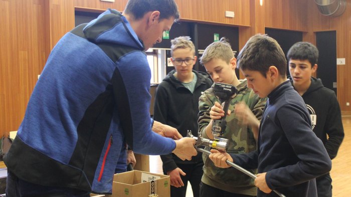 Tag des Handwerks in Jenesien Junge lernt mit dem Lehrer Werkzeuge in einem Holzraum zu benutzen