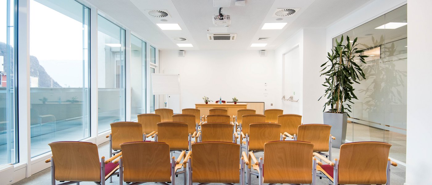 Vermietung Seminarräume moderner konferenzraum mit reihen von holzstühlen und tisch am ende
