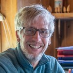 Oberpustertal Lächelnder Mann mit Brille und grauen Haaren in einem hellen Raum