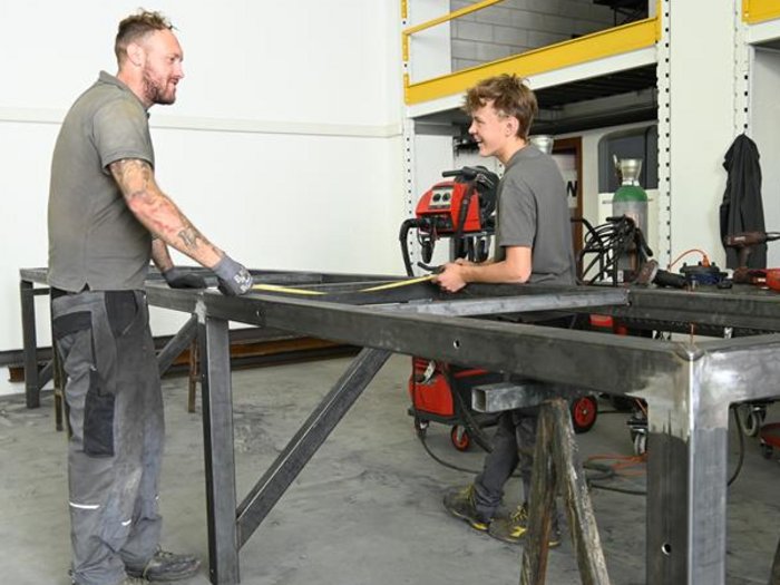 Mettersi all'opera con mani e cuore: l'apprendista fabbro Jakob Lantschner racconta la sua formazione artigianale Due operai misurano insieme una struttura metallica in una officina