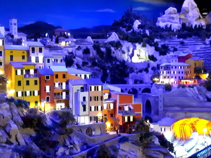 Die Althandwerker besuchen Hamburg Modellbahnlandschaft mit bunten Häusern und beleuchtetem Tunnel in den Bergen bei Nacht