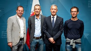 News Vier Männer vor Fahne und blauem Hintergrund mit Schrift Provinz Bozen Südtirol