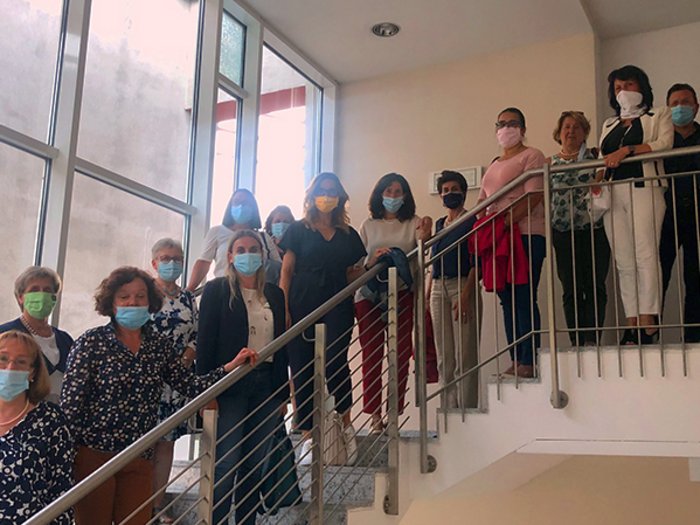 Eine geballte Ladung Frauenpower Gruppe von Menschen mit Gesichtsmasken auf einer Treppe in Innenraum