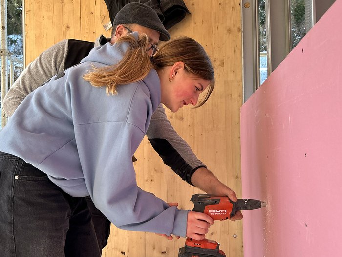 Handwerk zum Anfassen: SkillsDay begeistert im Oberpustertal Frau mit Bohrmaschine bohrt in rosa Wand, Mann hilft dabei