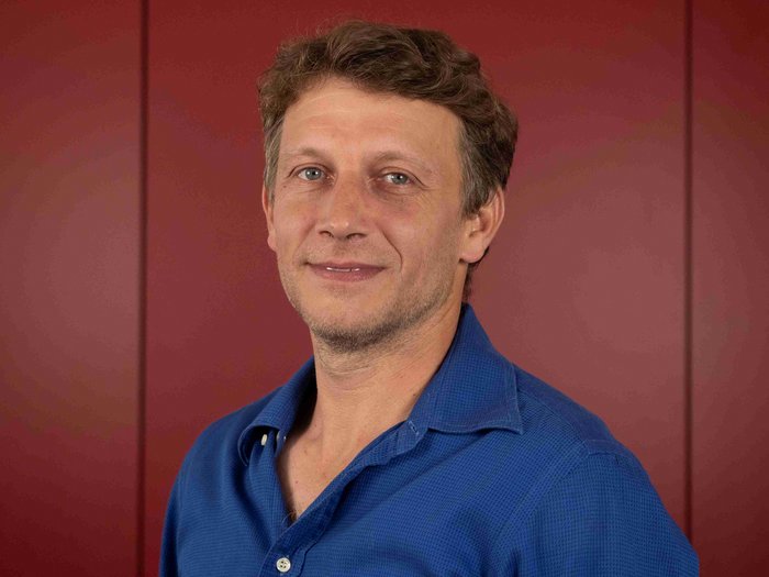 Hansjörg Brugger als Ortsobmann bestätigt Mann mit kurzem braunem Haar und blauem Hemd vor rotem Hintergrund