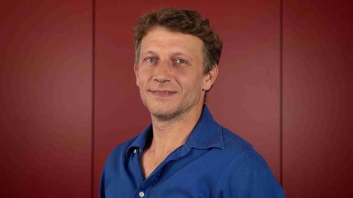 Hansjörg Brugger als Ortsobmann bestätigt Mann mit kurzem braunem Haar und blauem Hemd vor rotem Hintergrund