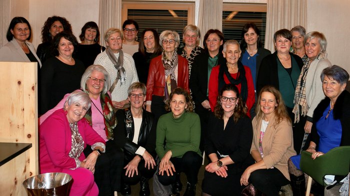 Weihnachtsessen - Bezirk Burggrafenamt Gruppenfoto von 22 Frauen in einem Innenraum vor einem Fenster mit Vorhängen