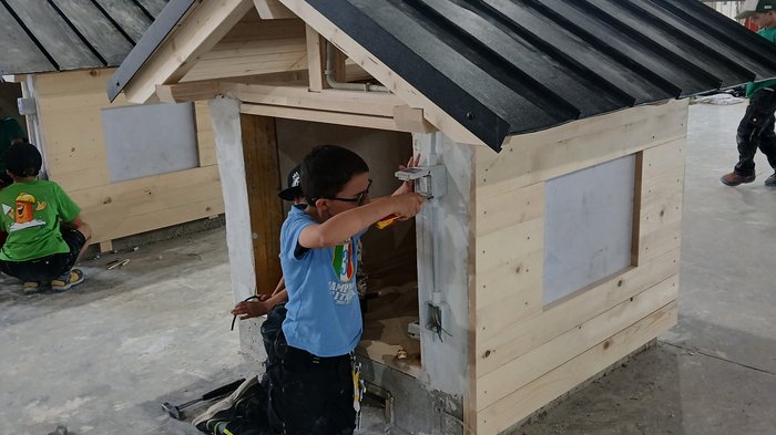 Mini-Baustelle, große Meisterwerke – KidsAcademy mauert in Bruneck Kinder arbeiten in einer Werkhalle an kleinen Holzmodellen von Häusern