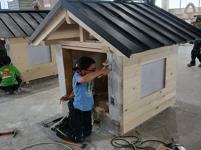 Mini-Baustelle, große Meisterwerke – KidsAcademy mauert in Bruneck Kinder arbeiten in einer Werkhalle an kleinen Holzmodellen von Häusern