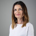 Barbara Ziviani Ritratto di donna con capelli castani e maglietta bianca su sfondo grigio