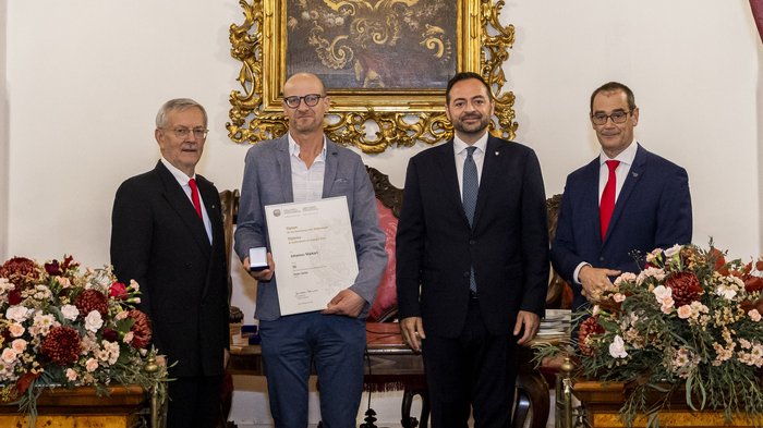 Südtiroler Wirtschaftspreis 2024 Vier Männer bei einer Ehrungszeremonie, einer hält Urkunde und Medaille