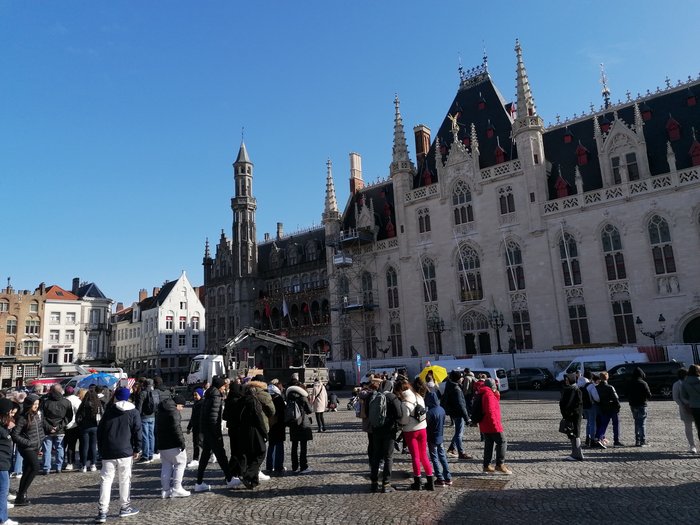 Althandwerker/innen im Herzen der Europäischen Union Menschenmenge vor historischem Gebäude mit gotischer Architektur unter klarem Himmel