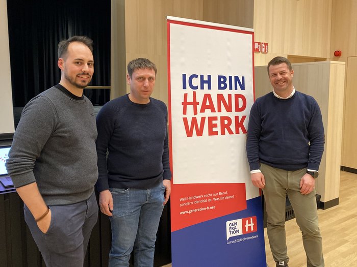 Handwerk in St. Leonhard: Gemeinschaft, Zukunftspläne und starke Perspektiven Drei Männer stehen vor einem Banner mit dem Text Ich bin Handwerk