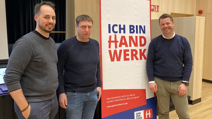 Handwerk in St. Leonhard: Gemeinschaft, Zukunftspläne und starke Perspektiven Drei Männer stehen vor einem Banner mit dem Text Ich bin Handwerk