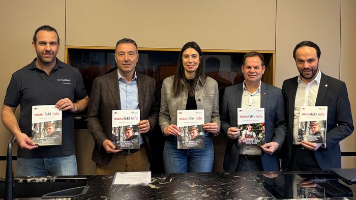In azienda già a 14 anni Cinque persone tengono in mano una copia della rivista manufakt info davanti a una parete