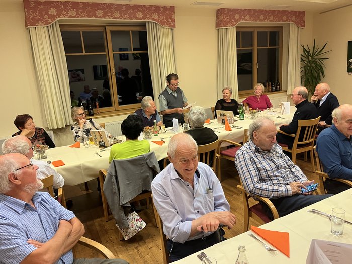 Althandwerker/innen unterwegs: Rundfahrt Weinviertel Gruppe älterer Menschen bei einer Versammlung an einem langen Tisch in einem Raum