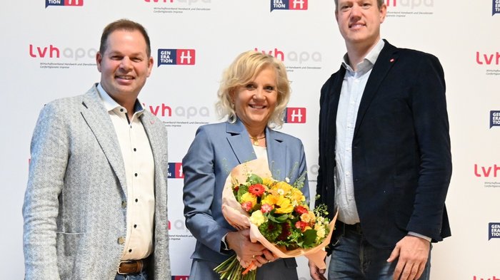 Wintersaison für gesamte Wirtschaft unabdingbar Drei Personen mit Blumenstrauß vor lvhapa-Werbewand