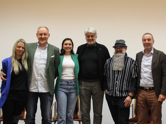 Il futuro del settore acconciatura al centro dell'attenzione: assemblea annuale 2024 Sei persone in piedi una accanto all'altra davanti a una parete bianca che sorridono