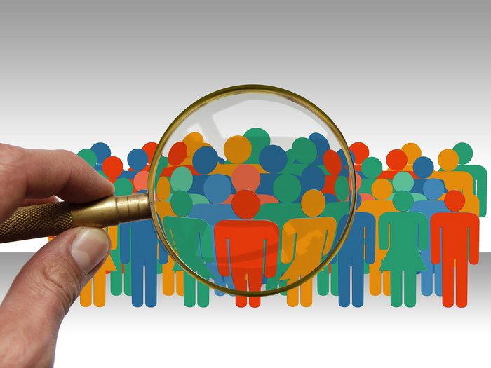 „Retribuzioni, non si può prescindere dalle peculiarità dei singoli settori“ Lente d'ingrandimento su pittogrammi colorati di persone in una folla