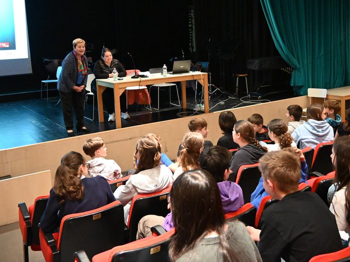 A lezione di artigianato presso la scuola media “Archimede” Due donne parlano davanti a un pubblico di adolescenti in teatro
