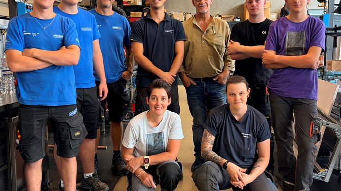 Quattro Paesi, le stesse domande: cosa interessa la falegnameria oltre i confini Nove persone posano insieme in un'officina
