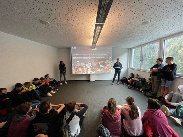 © Mitteschule Pankraz und Ulten Jugendliche sitzen im Kreis und hören einem Vortragenden im hellen Klassenraum zu