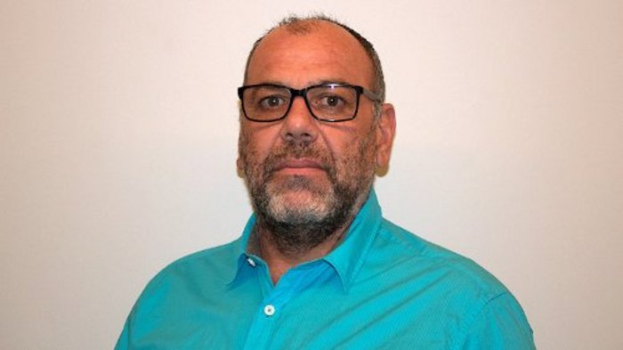 Sportgerätetechniker informieren Porträt eines Mannes mit Brille und blauem Hemd vor weißem Hintergrund