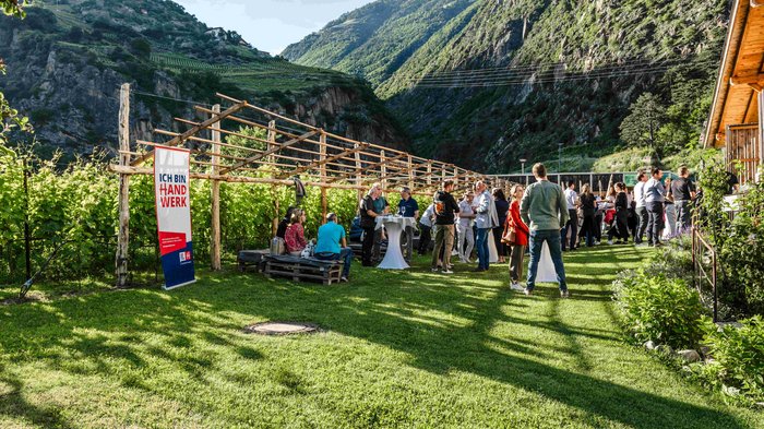 Consegna della spilla d’oro di lvh.apa Persone riunite all'aperto in una valle con montagne sullo sfondo sotto il sole