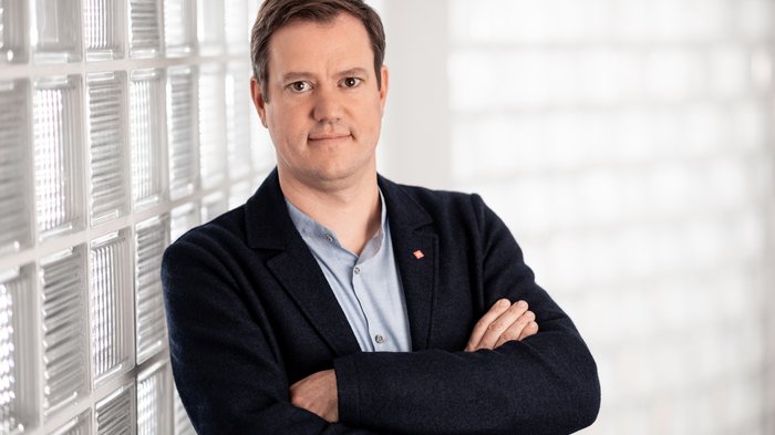 lvh-Präsident Martin Haller, ©Florian Andergassen Mann mit verschränkten Armen steht vor einer Wand aus Glasbausteinen