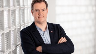 lvh-Präsident Martin Haller, ©Florian Andergassen Mann mit verschränkten Armen steht vor einer Wand aus Glasbausteinen