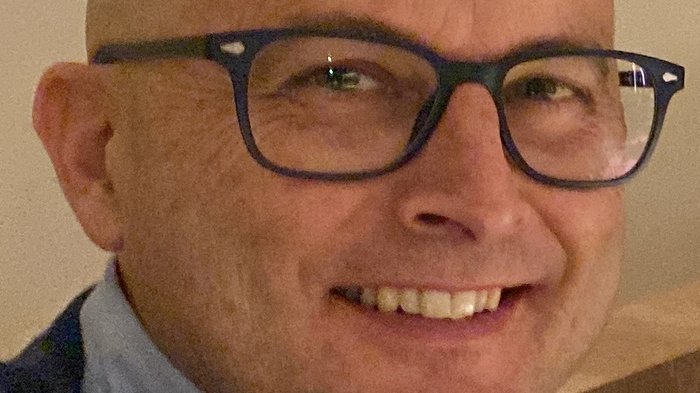 Wichtiges Treffen zum Thema Sondertransporte Lächelnder Mann mit Brille und Glatze in einem hellen Raum