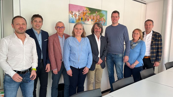 Un passo avanti verso il rafforzamento dell'assistenza sanitaria territoriale Otto persone in piedi una accanto all'altra in una sala riunioni moderna