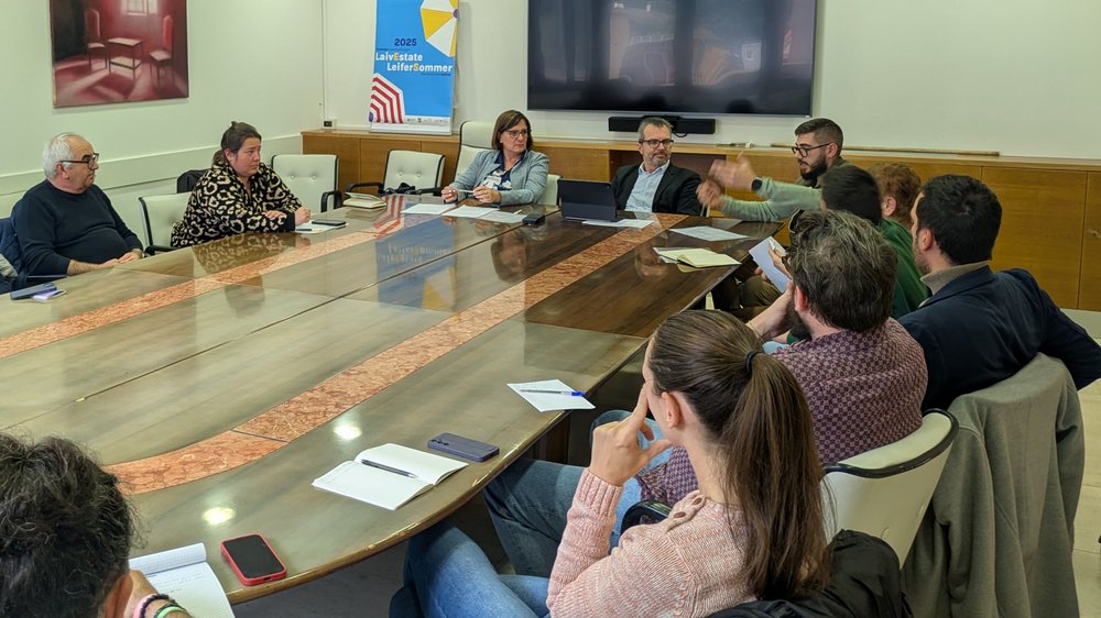 Home Persone in una sala riunioni durante una conferenza intorno a un tavolo