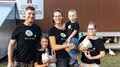 © Südtiroler Bauernbund Familie mit Hühnern vor Hühnerstall trägt schwarze Ei love you T-Shirts