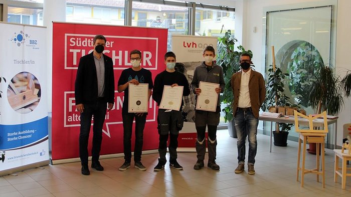 22. Jugendwettbewerb der Tischler im Berufsbildungszentrum Bruneck Fünf Personen mit Zertifikaten bei einer Tischler-Auszeichnung, alle tragen Masken
