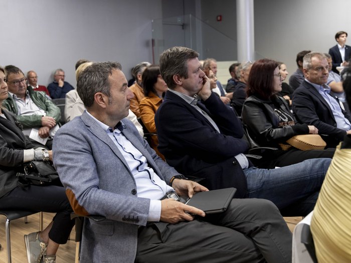 Südtiroler Meisterbund: neuer Rat der Meister gewählt Menschen in einem Konferenzraum hören einer Präsentation aufmerksam zu