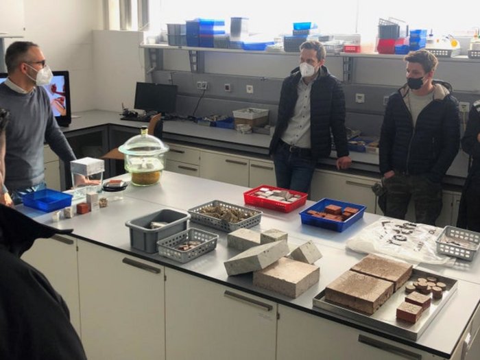 Innovation und Digitalisierung neuer Baustein der Meisterausbildung Personen mit Masken im Labor mit Baustoffproben auf Tisch