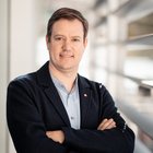 L'intelligenza artificiale nell'artigianato Ritratto di uomo con giacca e braccia incrociate in edificio moderno.