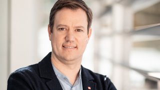 lvh-Präsident Martin Haller, Foto: ©Florian Andergassen Porträt eines Mannes im Blazer mit verschränkten Armen in einem modernen Gebäude.