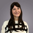 Imprese movimento terra Ritratto di donna sorridente con capelli lunghi neri e maglione a righe