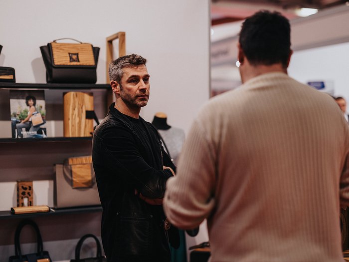 Gran successo della Fiera dell’Economia della Val d‘Isarco: circa 20.000 visitatori entusiasti Due uomini parlano davanti a una mensola con borse e accessori in esposizione