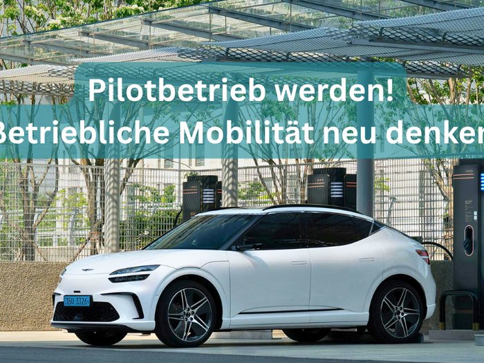 Betriebliches Mobilitätsmanagement – 10 Arbeitgeber*innen für Pilotprojekt gesucht! Weißes Elektroauto an Ladesäule unter Dach im urbanen Umfeld