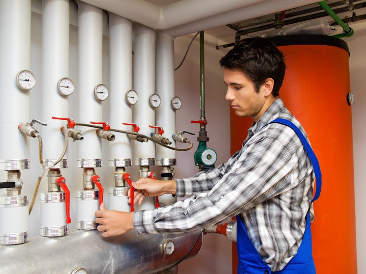 Bruciatoristi Tecnico regola valvole e manometri su impianto di riscaldamento