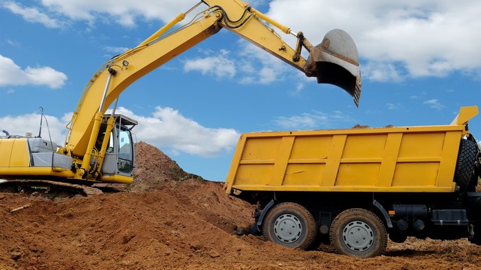 WIFO - Wirtschaftsbarometer Frühjahr 2025 Baugewerbe: positives Geschäftsklima trotz abgeschwächter Nachfrage Gelber Bagger lädt Erde in einen gelben Muldenkipper unter blauem Himmel