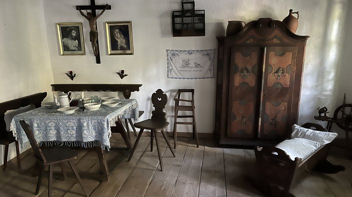 Althandwerker/innen unterwegs: Rundfahrt Weinviertel Traditionelles Bauernzimmer mit Holzmöbeln, Kreuz und Kinderwiege