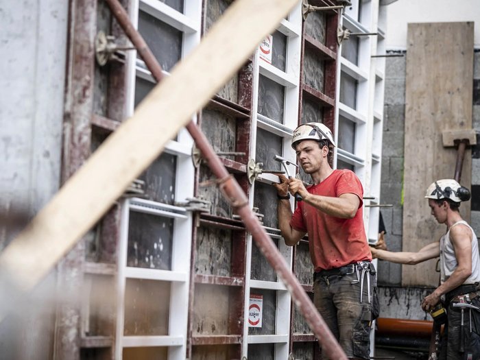 Barometro dell’economia IRE – Autunno 2025 - Costruzioni: redditività soddisfacente nel 2025, moderato ottimismo per il 2026 Due operai con caschi lavorano a una parete di cemento in un cantiere edile