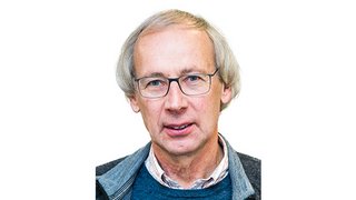 News Älterer Mann mit Brille und grauem Pullover vor weißem Hintergrund