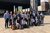 Foto di gruppo di 19 persone davanti a edificio moderno con opera d'arte