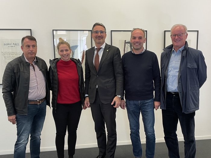 Landeshauptmann und Frächter suchen gemeinsam nach Lösungen für die Transportbranche Fünf Personen stehen nebeneinander vor einer weißen Wand mit gerahmten Bildern